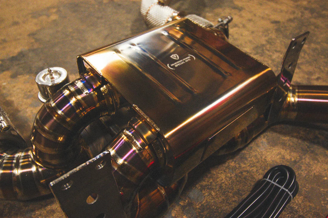 A close view of Valvetronic Designs Titanium Valved Sport Exhaust System's muffler on the ground (for Mclaren 720S).