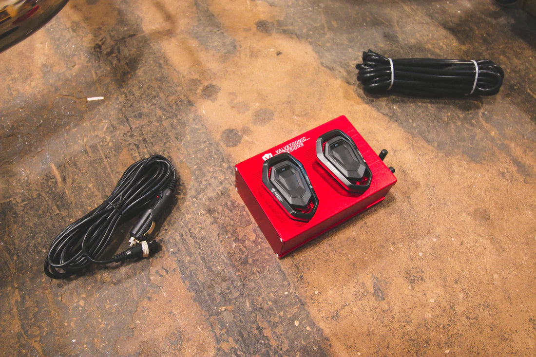 A close up view of Valvetronic Designs Valved Sport Exhaust System's valve controllers and wires on the ground (for Ford Mustang GT S550)