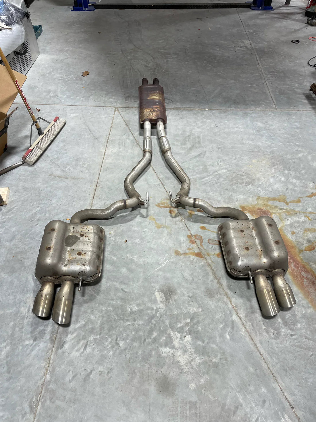 A wide view of Valvetronic Designs Valved Sport Exhaust System's pipes on the ground (for Ford Mustang GT S550)