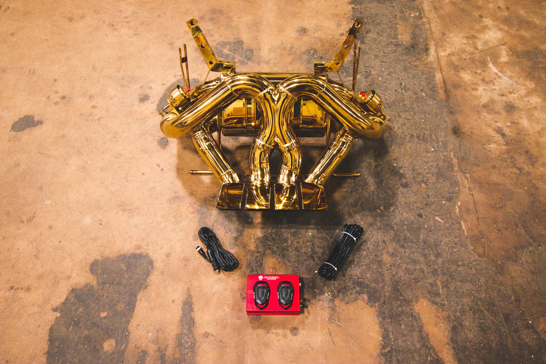 A top overview of Valvetronic Designs Valved Sport Exhaust System with valve controllers on the ground (for Lamborghini Aventador LP700 / SV).