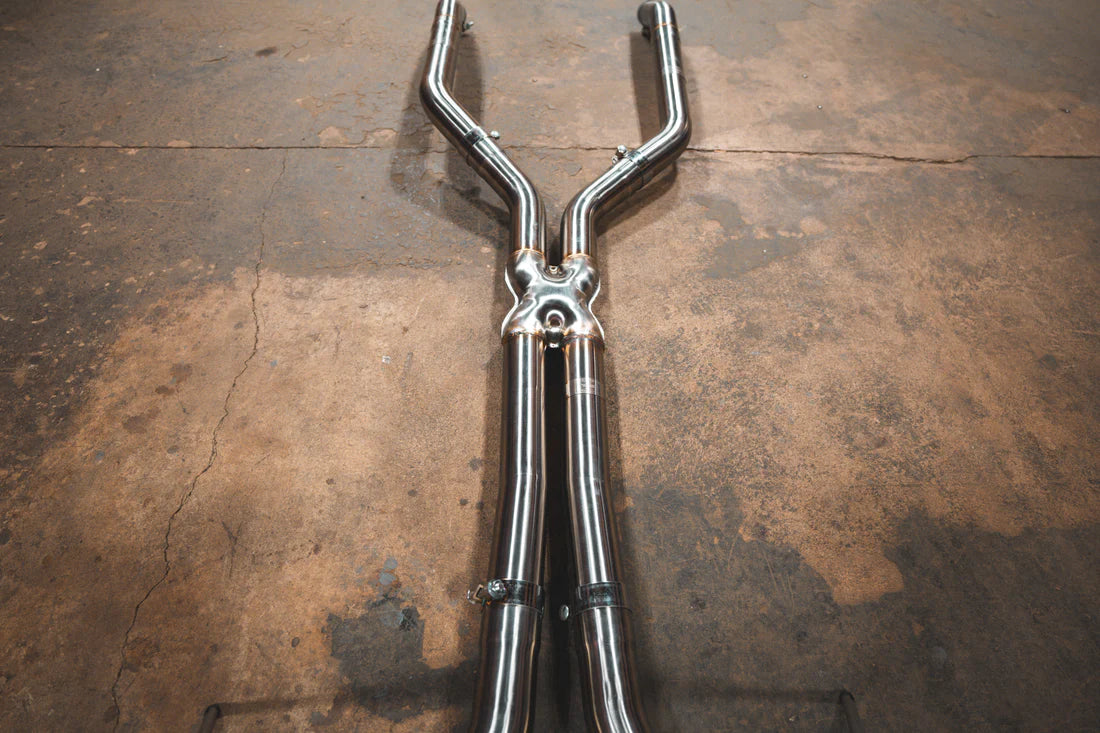 A wide view of Valvetronic Designs Valved Sport Exhaust System's pipes on the ground (Alpina B6 / BMW 650i).