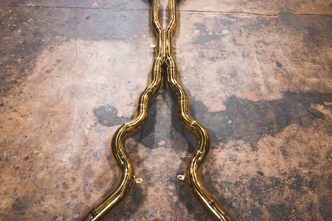 A close overview of Valvetronic Designs Valved Sport Exhaust System's pipes on the ground (for BMW F10 M5 / F12 M6 / F06 M6).