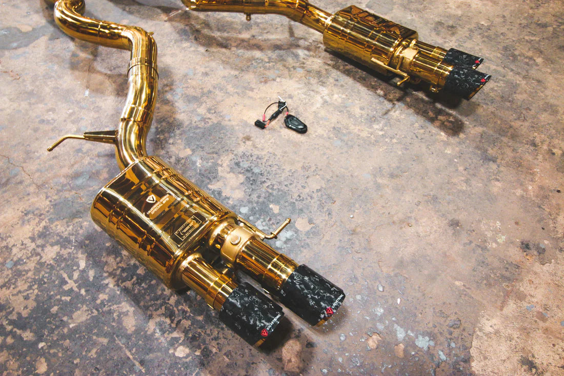 A close overview of Valvetronic Designs Valved Sport Exhaust System with Forged Carbon Fiber exhaust tips on the ground (for BMW F10 M5 / F12 M6 / F06 M6).