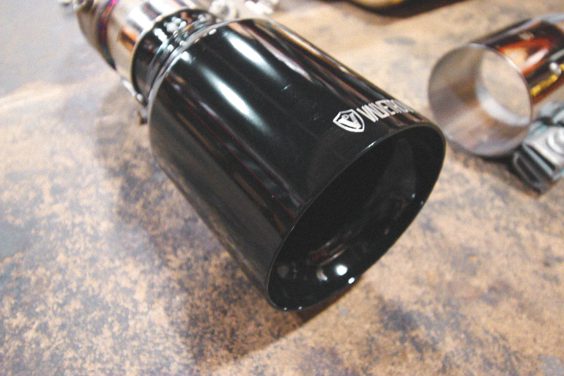 A view of Valvetronic Designs Valved Sport Exhaust System's exhaust tip in Black on the ground (for BMW F30 / F22 / F36 / F32). 