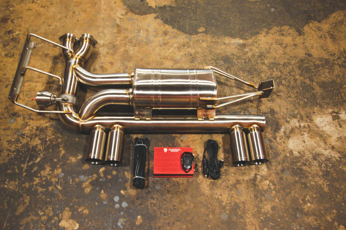 A top overview of Valvetronic Designs Valved Sport Exhaust, with wires and a red box on the ground (for BMW E46 M3).