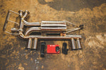 A top overview of Valvetronic Designs Valved Sport Exhaust, with wires and a red box on the ground (for BMW E46 M3).