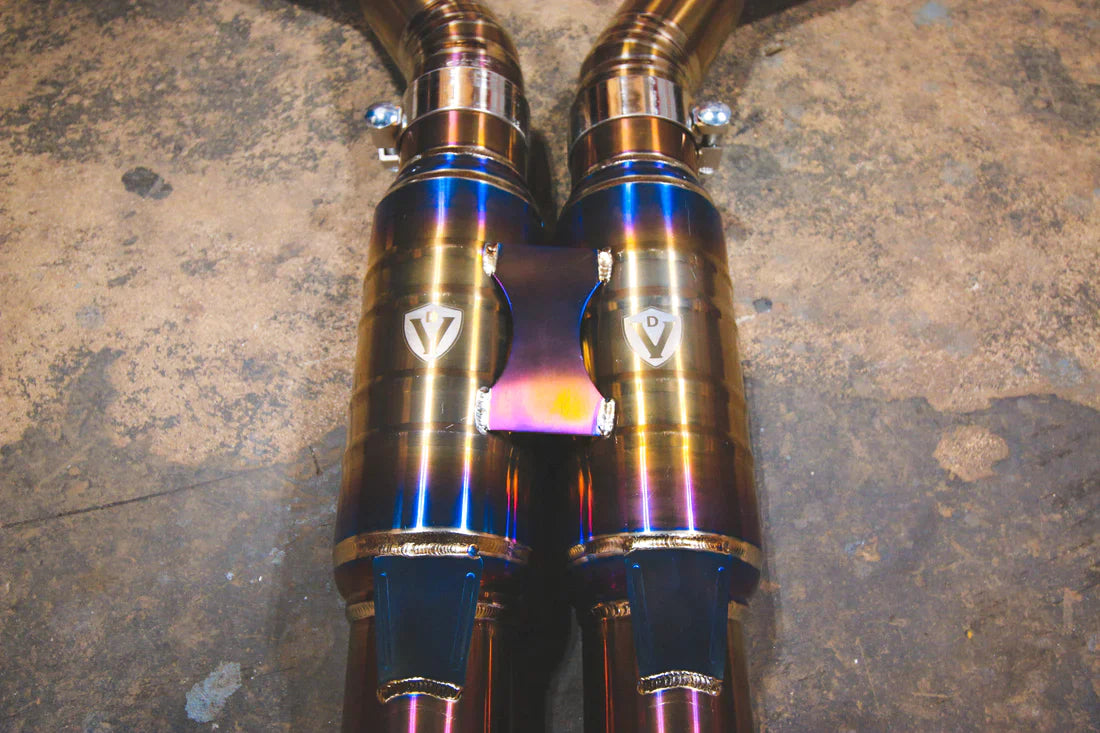 A close overview of Valvetronic Designs Titanium Grade 5 Valved Sport Exhaust System's pipes on the ground (for BMW F10 M5 / F12 M6 / F06 M6).