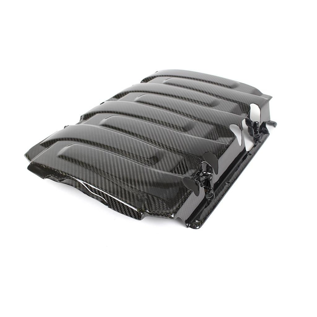 Black carbon fiber engine cover with raised vented sections and chrome mounting brackets on white background - APR Performance engine cover for Chevrolet Camaro SS LT1