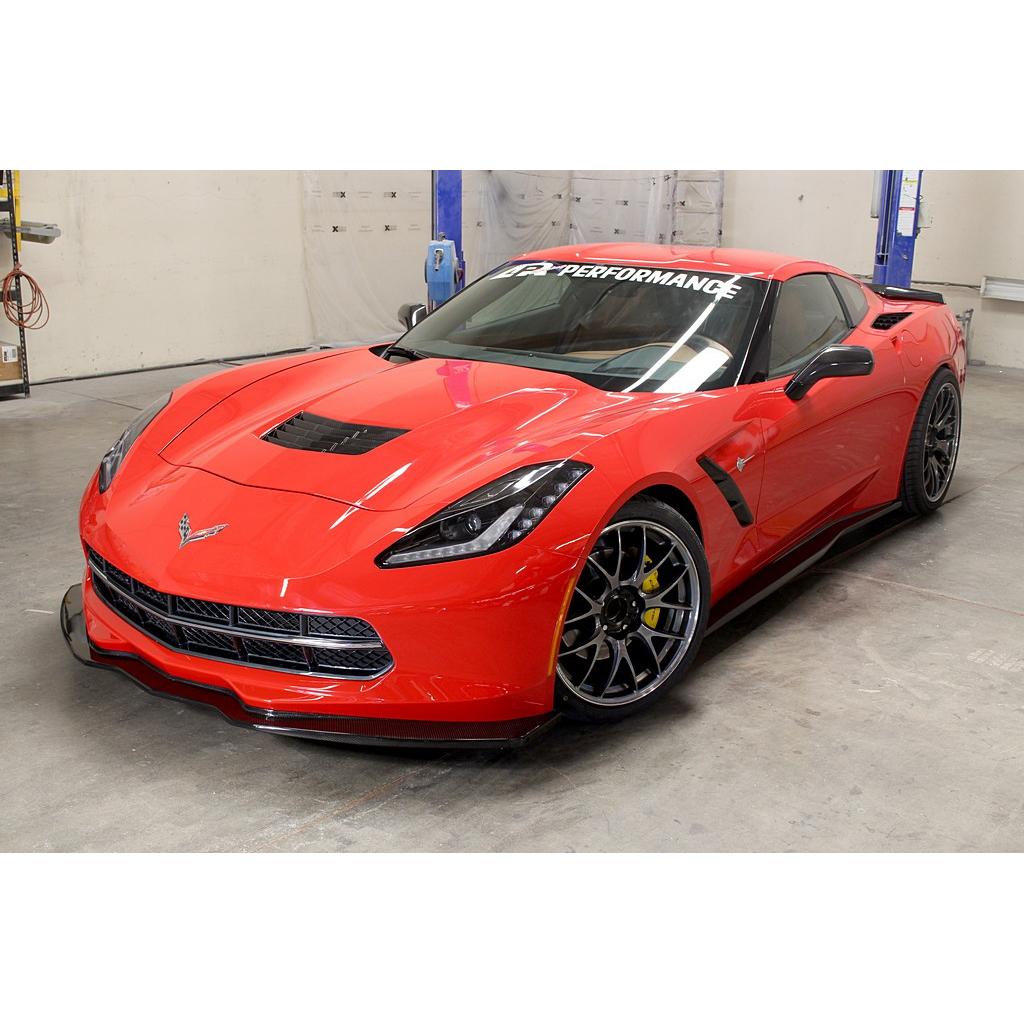 Red Corvette with black carbon fiber front airdam splitter installed in garage workshop setting - APR Performance front airdam for Chevrolet C7 Corvette Corvette Z06