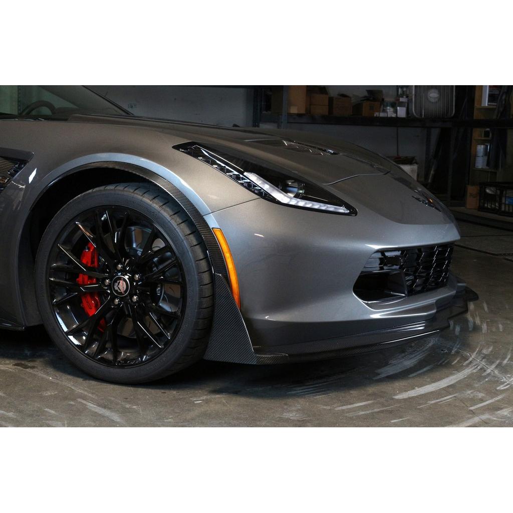 Black carbon fiber front airdam splitter with angular canards installed on silver Corvette front bumper in garage - APR Performance front airdam for Chevrolet C7 Corvette Corvette Z06