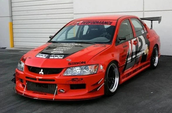 A front view of a red car fitted with APR Performance EVIL-R Widebody Aerodynamic Kit Mitsubishi Evolution IX 2006-2007