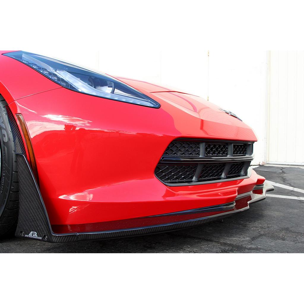 Black carbon fiber front airdam splitter installed on red Corvette, extending below front bumper with mounting hardware visible - APR Performance front airdam for Chevrolet C7 Corvette Corvette Z06