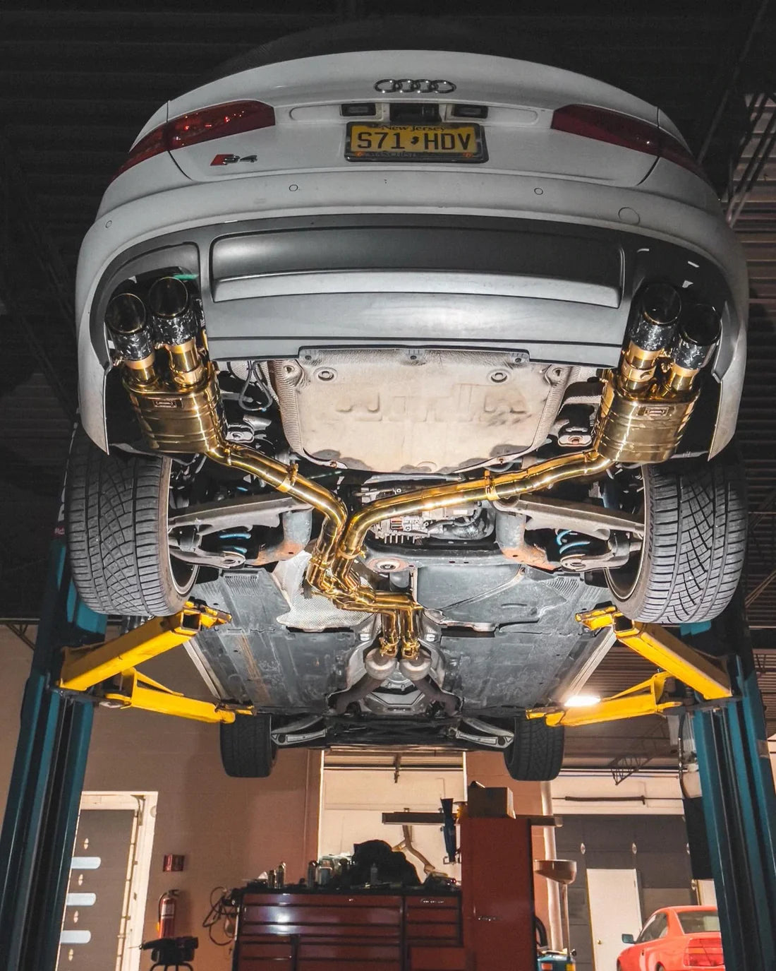 A wide view of Valvetronic Designs Valved Sport Exhaust System (for Audi B8 / B8.5 S4 / S5) fitted on a car from under.  