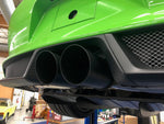 A close up side view of Shark Werks 100mm Exhaust Tips for Porsche 991 / 991.2 GT3 / RS / R fitted on a green car from behind 