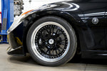 A side close up view of a black car with the front wheel fitted with AP Racing by Essex Radi-CAL ENP Competition Brake Kit (Front CP9660/372mm)- Nissan 370Z