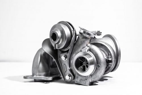 A close up side view of Pure Turbos BMW N54 Pure STG1 Upgrade Turbos behind a white background