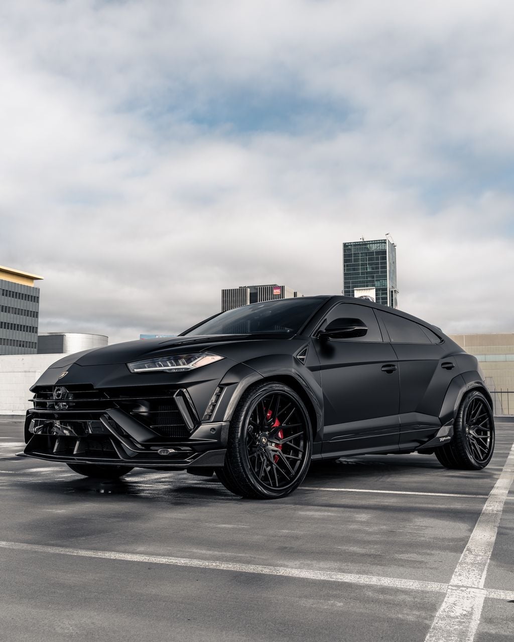 Black Lamborghini Urus front three-quarter in a parking structure