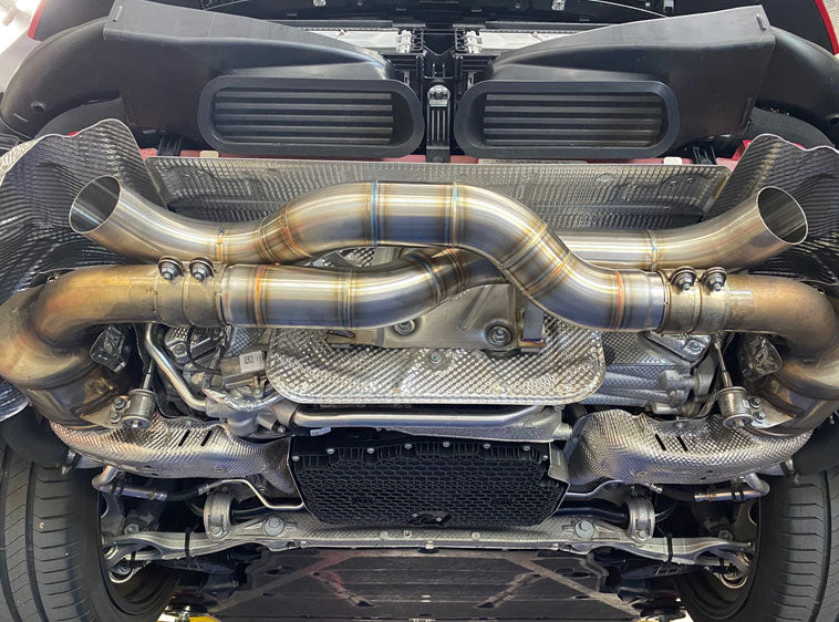 A view of Shark Werks Race Exhaust for Porsche 992 / Carrera / S / Turbo fitted on a car from underneath
