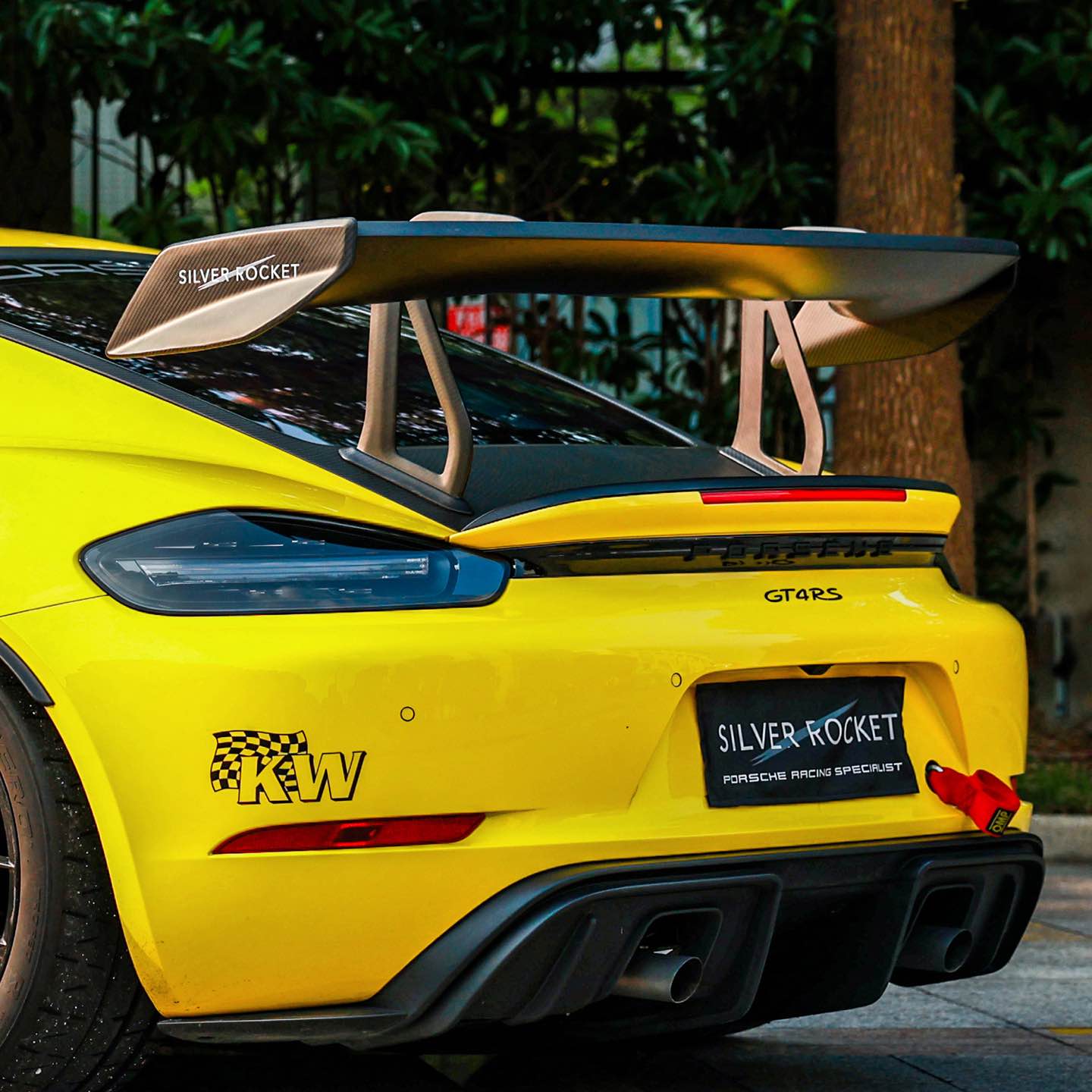Rear view of a yellow GT4rs with silver rocket carbon wing