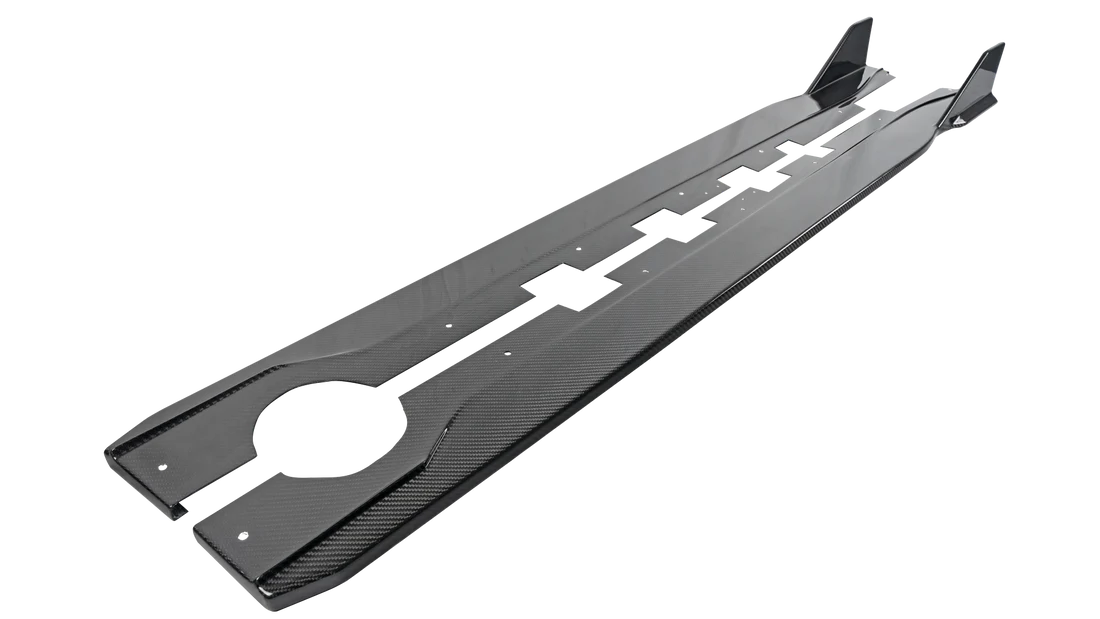 A front view of side rocker extensions of APR Performance Carbon Fiber Aero Kit Subaru BRZ 2022+ with white background