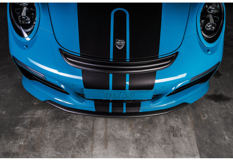 A top view of TECHART Air Outlet Grille Carbon Glossy Porsche 991.2 Carrera / Targa / Turbo fitted on a blue and black Porsche