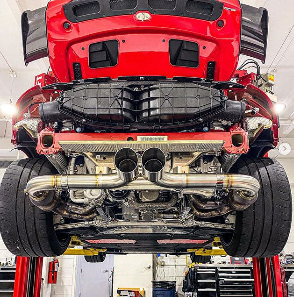 A wide view of Shark Werks Track Exhaust for Porsche 991 / 991.2 GT3 / RS fitted on a red car from the back