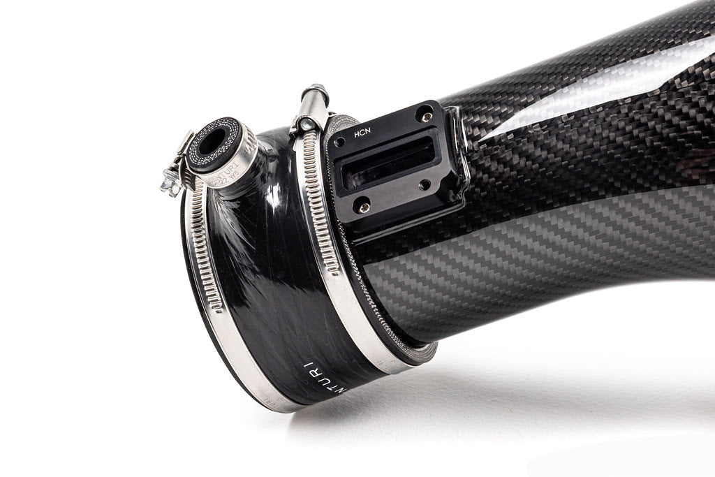 A side close up view of the couplers of the Eventuri Black Carbon Intake System for Lamborghini Huracan EVO / STO 2019-2025 with white background