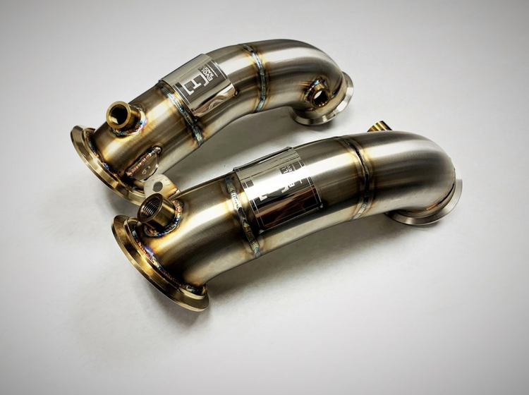 A top view of Evolution Racewerks Competition Series Catless Primary Downpipe BMW S63M Engine in Brushed Finish