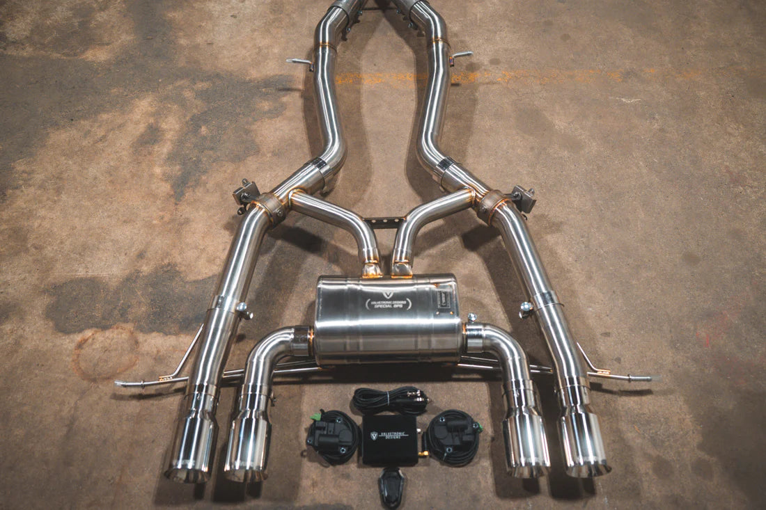 A close view of Valvetronic Designs Axleback Valved Sport Exhaust System with Chrome exhaust tips on the ground (for BMW G8x M3 / M4).