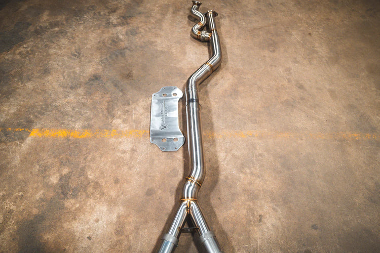 A top overview of Valvetronic Designs Equal Length Midpipe in Brushed Stainless Steel on the ground (for BMW G8x M3 / M4).